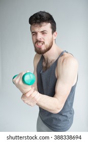 Skinny Man Training His Bicep Muscle. Guy Lifting One Dumbbell. Young Student Training To Become Stronger