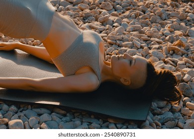 Skinny woman doing stretching on rocky seashore. Outdoor activity, working on flexibility and joint mobility - Powered by Shutterstock