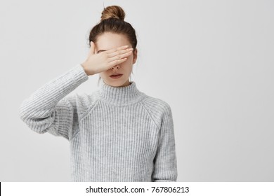 Skinny Woman Wearing Grey Outfit Closing Her Eyes With Hand. Confident Female Trying To Hide Her Face From Other People Prefer Not To See. Decision, Human Concept