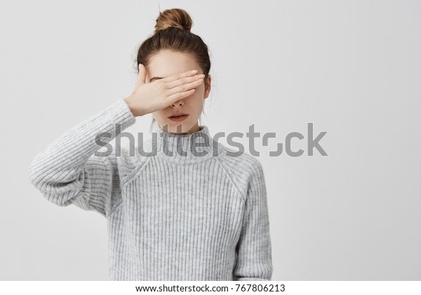 グレイの服を着て手で目を閉じた痩せた女性 他の人に顔を隠そうとする自信のある女性は 見たくない 決断 人間のコンセプト の写真素材 今すぐ編集