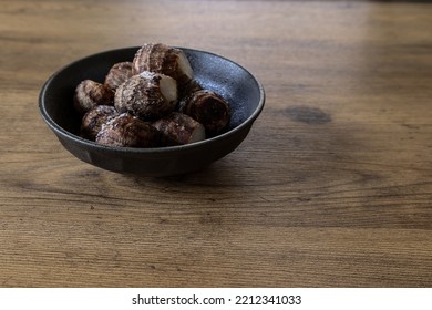 Skin-on Boiled Taro Corm In A Black Crockery On A Wooden Table.