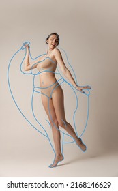 Skipping rope drawings  Young beautiful woman in inner wear and perfect body shape posing in underwear isolated over grey background  Concept healthy eating  dieting  weight loss  fitness  ad