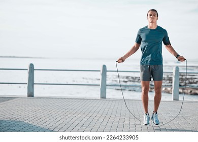 Skipping rope, mockup and man training by the beach for his outdoor morning exercise, workout and fitness routine. Athlete, cardio and male jump by the ocean or sea for wellness lifestyle - Powered by Shutterstock