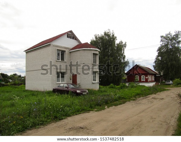 Skopin, Russia -\
August 6, 2019. New white brick cottage under construction and old\
wooden house in Pravda\
street.
