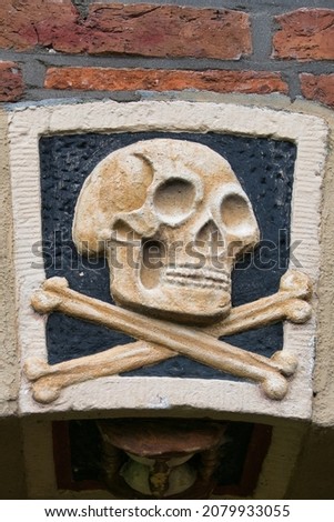 Skull and bones. Closeup of an 18th century facade stone on the Tower Church (Torenkerk) in Winsum, the Netherlands
