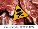 Skull and crossbones sign on raw meat, top view. Be careful - toxic