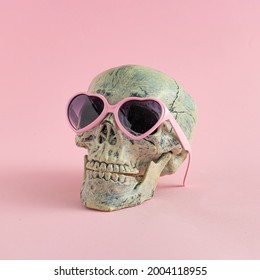 Skull with glasses on pink background. Halloween creative fashio