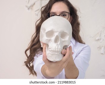 skull in the hands of a girl doctor