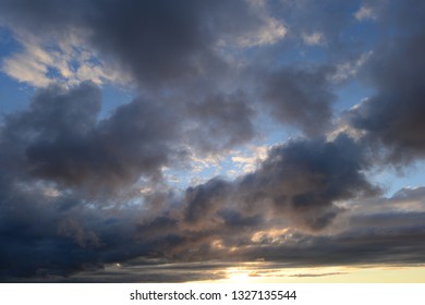 sky background in dark clouds in the rays of sunlight at sunset
