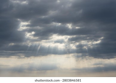 Sky Background. Detail view of a cloudscape with sun's rays piercing through storm clouds