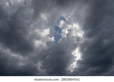 Sky Background. Detail view of a cloudscape with sun's rays piercing through storm clouds