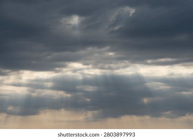 Sky Background. Detail view of a cloudscape with sun's rays piercing through storm clouds
