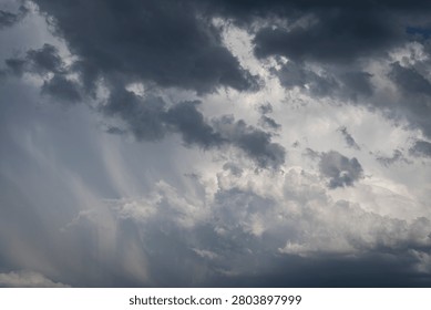 Sky Background. Detail view of a cloudscape with sun's rays piercing through storm clouds