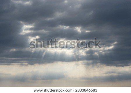 Sky Background. Detail view of a cloudscape with sun's rays piercing through storm clouds