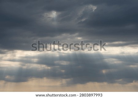 Sky Background. Detail view of a cloudscape with sun's rays piercing through storm clouds