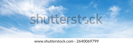 sky is blue and clear with clouds. The sun is shining brightly, making the sky look even brighter. Scene is peaceful and serene