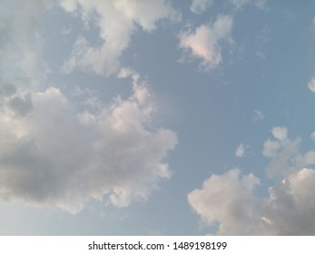 A Sky Blue Sky With Fluffy White Clouds. Like The Opening Scene Of Toy Story Or The Simpsons