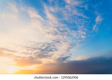 Sky blue and orange light of the sun through the clouds in the sky - Shutterstock ID 1295062906