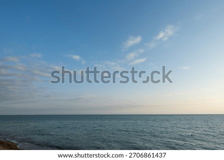 The sky is clear and blue with no clouds. The ocean is calm and peaceful. The scene is serene and relaxing