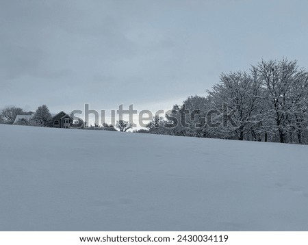 Sky clearing on the horizon over a rural property covered in snow after a winter storm in Pittstown, NJ in February 2024