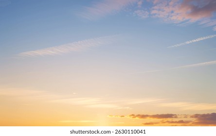 Sky with clouds during sunset featuring orange yellow and blue gradient colors.