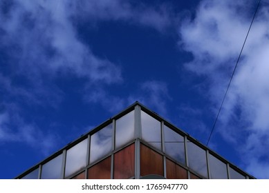 The sky with clouds is reflected in the Windows of a modern building.                 