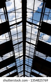 Sky with clouds seen from across the structure of an old roof. Can be used as background.