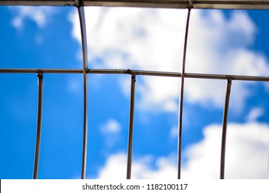 Sky And Clouds Seen Through Metal Gate.  Concept For Shattering The Glass Ceiling Or Freedom.