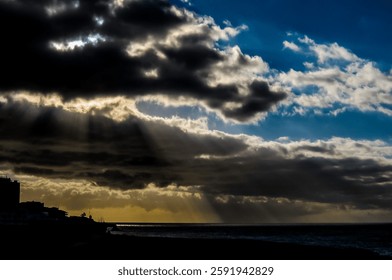 The sky is cloudy and the sun is shining through the clouds. The sun is casting a beautiful light on the water