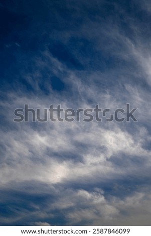 Sky covered with clouds. At the bottom, blue sky is still visible, but light gray clouds are moving in. Above, dark storm clouds dominate, creating a dramatic scene.