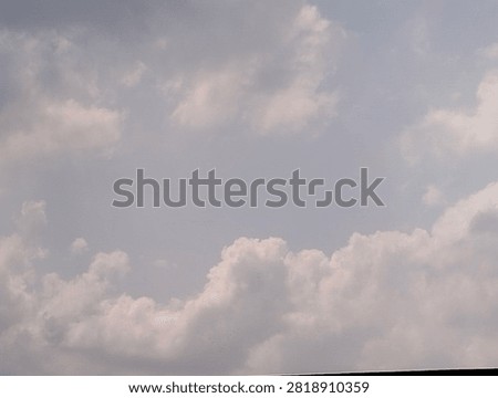 The sky is dominated by a layer of thin clouds at the top and denser clumps of Cumulus clouds below. The cloud colors range from grayish-white to a bright white where they catch the reflected sunlight.