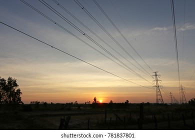 Sky in the evening has thin clouds and high voltage towers.