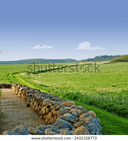 Sky, field and stone wall in countryside for farming, agro growth or crops for development in nature. Background, travel and landscape of meadow horizon, lawn or natural pasture for grass and ecology