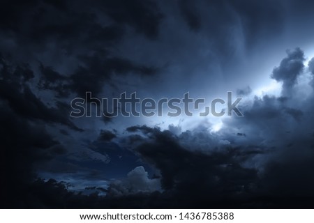 The sky is full of dark clouds in bad weather before a big storm rain. Light emission  from the Edge of clouds. Zoom the surface of a Black haze at close range.