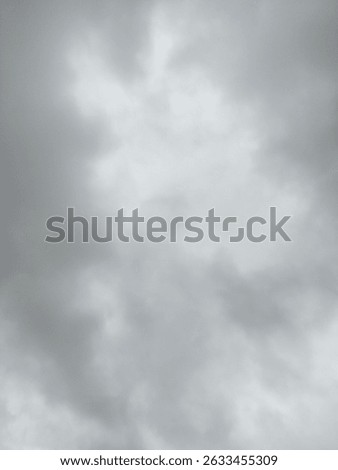 A sky fully covered with thick, dark gray clouds, suggesting an approaching storm or heavy rain. This overcast weather photo captures a somber, reflective mood and can be used in projects related to n