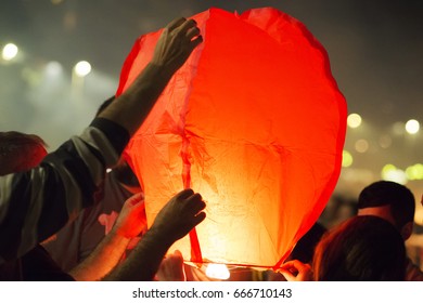  sky lantern being held by tourists closeup  in Saint John bonfires in Coruna  Galicia, feast of  international Tourist Interest