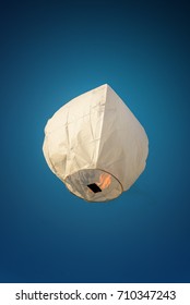 Sky Lantern in day light. White color thai sky lantern floating in blue sky.
