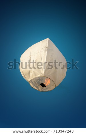 Sky Lantern in day light. White color thai sky lantern floating in blue sky.