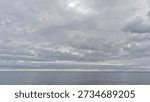 sky with layers of grey clouds over calm the Atlantic Ocean