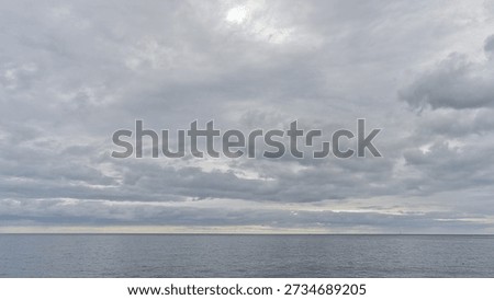 sky with layers of grey clouds over calm the Atlantic Ocean