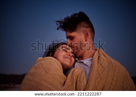 Sky, love and couple with blanket at night, enjoying the evening together. Young man and woman in relationship bond in star gazing, camping and cuddling. Travel, peace and people on nature holiday