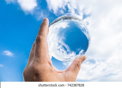 The sky reflected in the crystal ball,environment saving, abstract meaning environment in your hand.