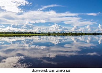 Sky Reflected In Water On A Lake In The Amazon Rainforest In Peru