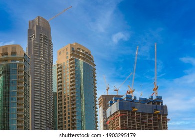 Sky Scraper Buildings With Blue Sky And Clouds With Under Construction Building And Big Cranes