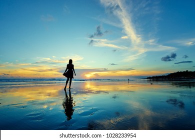 Sky And Sea. Beautiful Sunset. Silhouette Of Young Woman Walking On Ocean Beach.