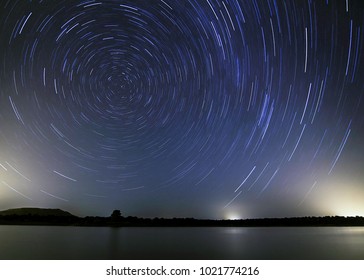 Sky With A Trail Of Stars Revolving On The Polar Star Indicating Where North Is On A Lake. 