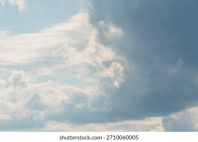 A sky with various cloud formations, dominated by dark cumulonimbus clouds contrasting against lighter cirrus and altocumulus Viewed from below, creating a sense of scale and depth No human-made ob