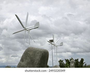 Sky with white clouds and 2 large windmills.