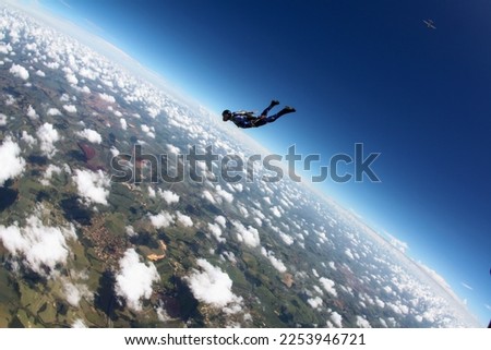 Skydiver diving alone in blue sky at sunny day, adventure concept.