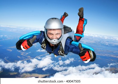 Skydiver falls through the air. All right! Thumbs up! Parachuting is fun!